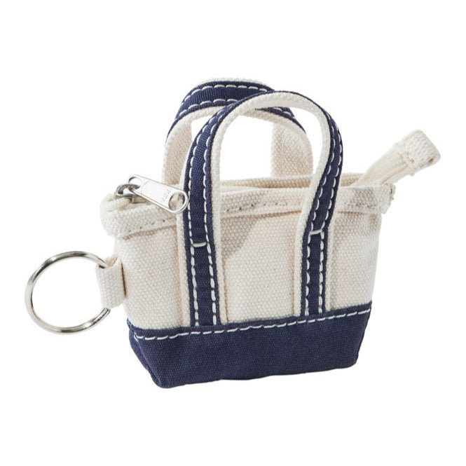 Small tote bag keychain with navy accents on a white background