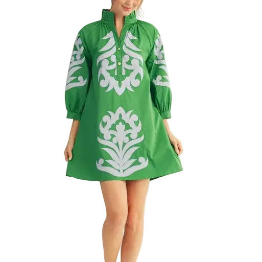 Woman wearing a green dress with white patterns on a beige background