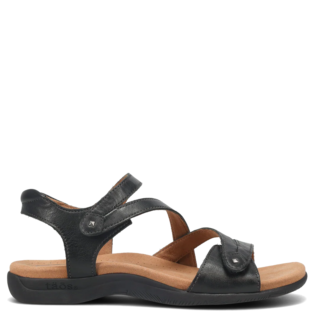 Black sandal with a brown sole on a white background
