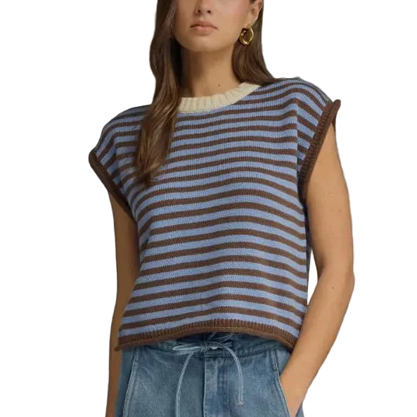 Woman wearing a striped top and blue jeans against a gray background