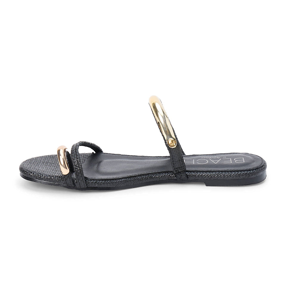 Black sandal with gold straps on a white background