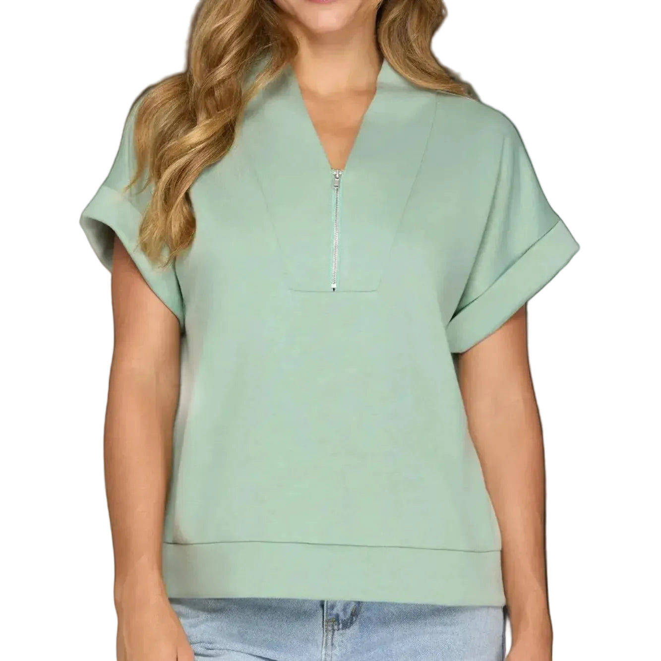 Woman wearing a light green short-sleeve top with a zipper on a plain background