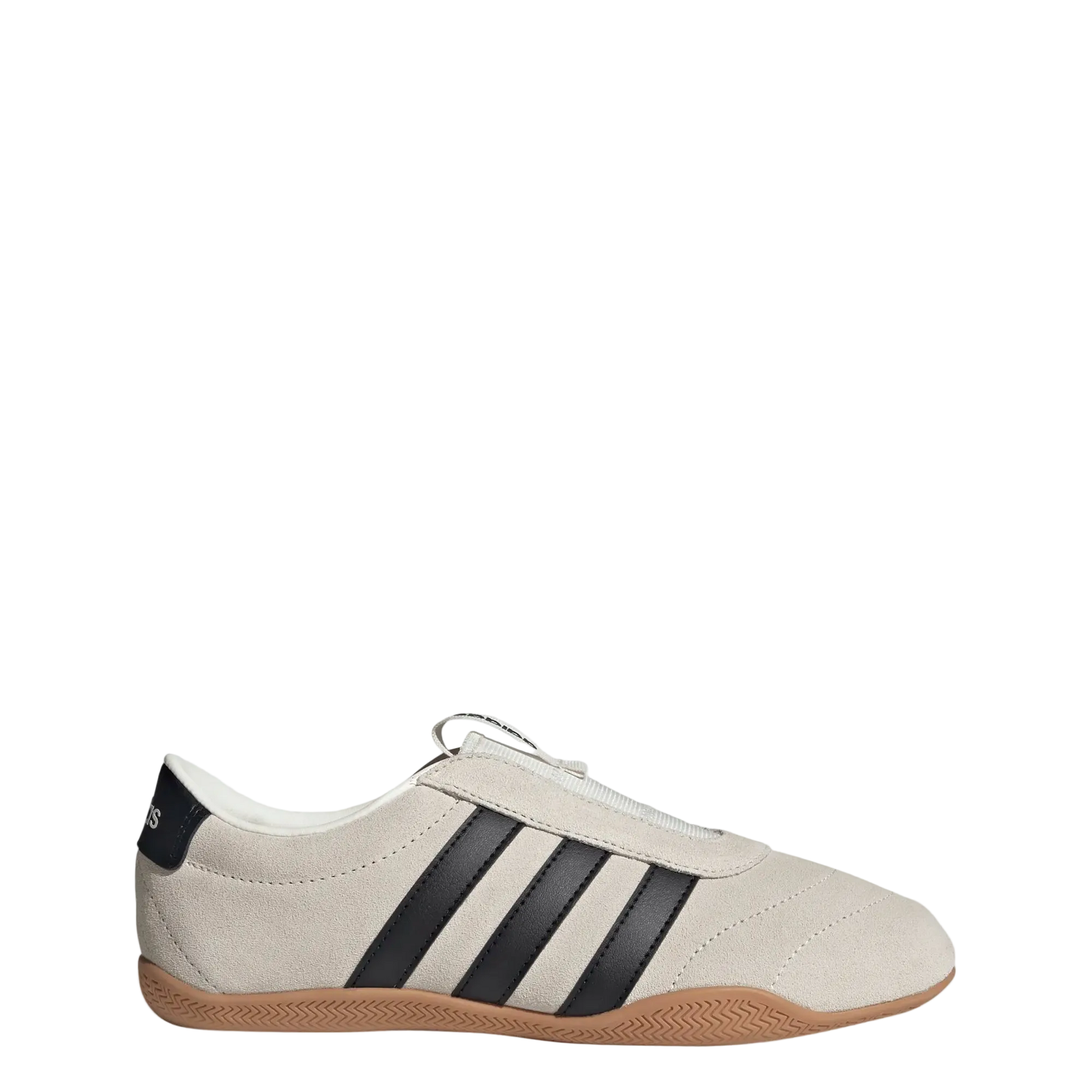 A low-top Adidas sneaker in off-white suede with three black stripes, a black heel tab, and a brown gum sole, shown against a light gray background.