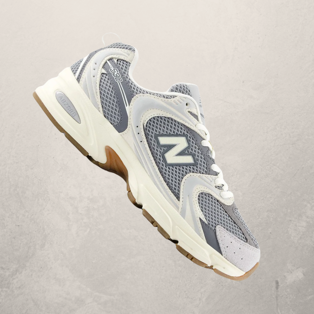 Gray and white sneaker with brown sole on a light gray background