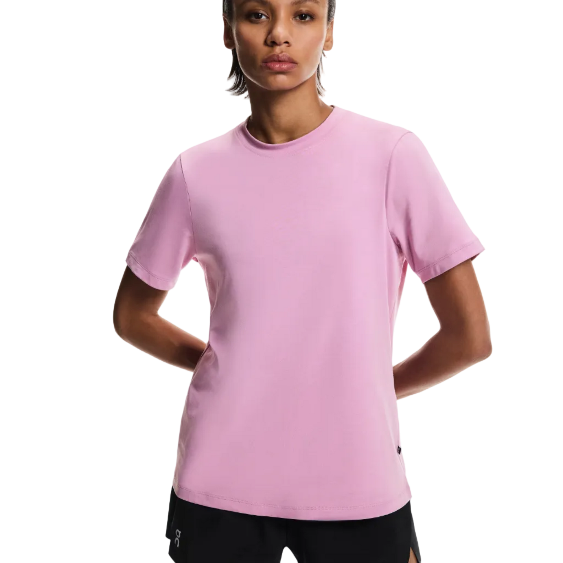 Woman wearing a pink t-shirt and black shorts on a white background
