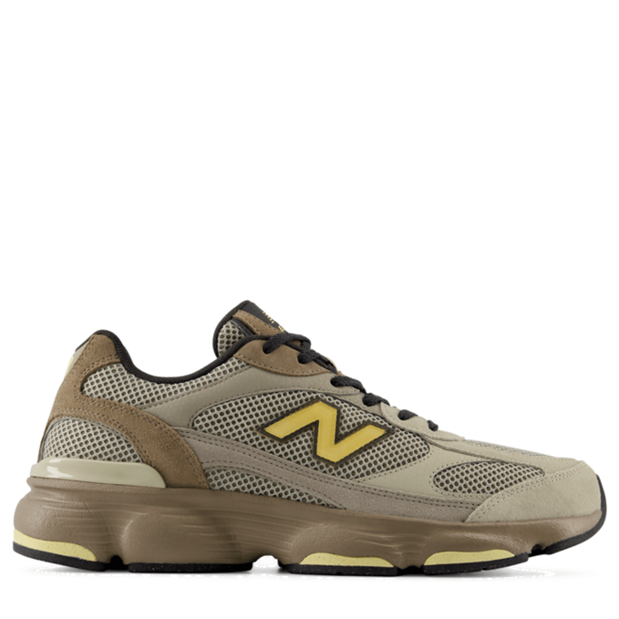 A New Balance sneaker in beige and brown with a yellow 'N' logo, shown from the side on a white background.