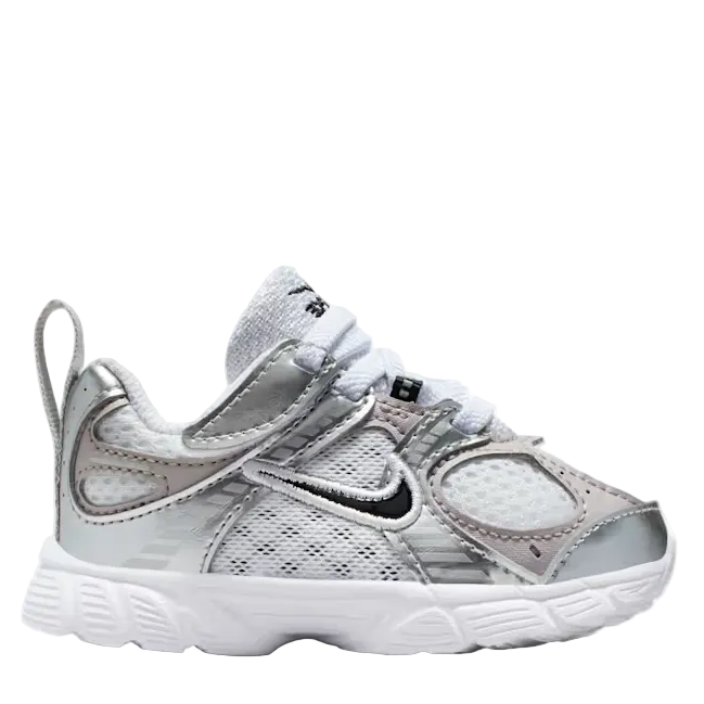 A Nike toddler sneaker in metallic silver and white, featuring a mesh upper, hook-and-loop strap closure, and a white sole, shown against a plain white background.