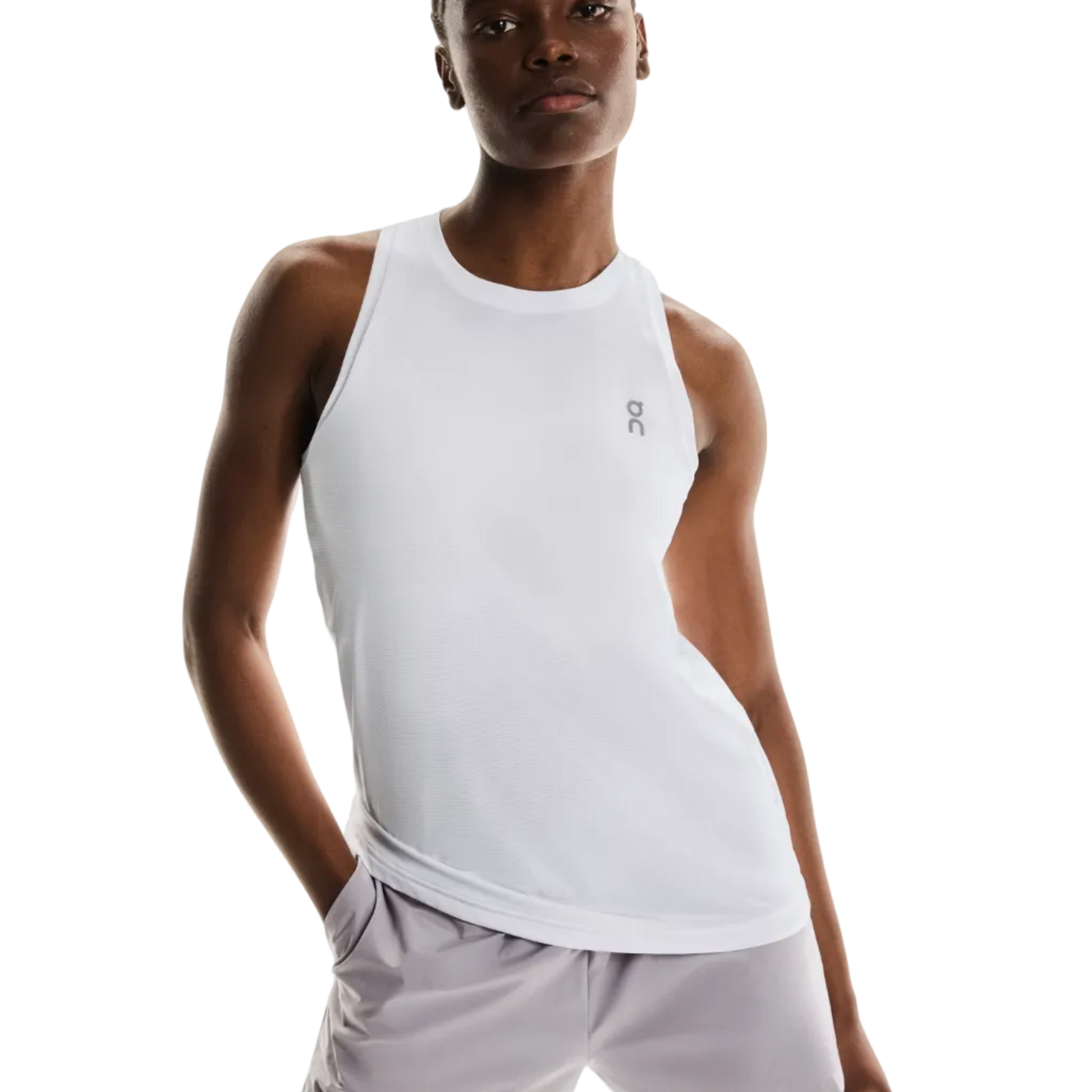 Woman wearing a white tank top and light gray shorts on a white background