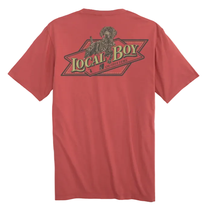 A red short-sleeve t-shirt shown from the back, featuring a large graphic print of a dog and the text 'LOCAL BOY OUTFITTERS' in green and black. 