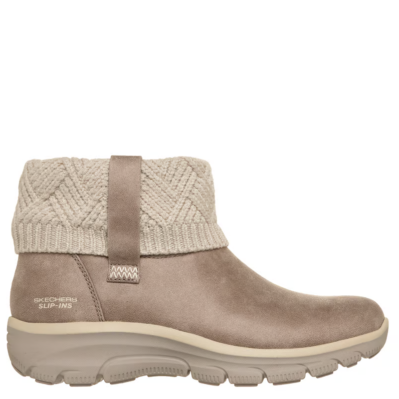 A Skechers Slip-In sneaker boot in taupe suede with a beige cable-knit cuff and a matching beige sole, shown from a side profile on a white background.