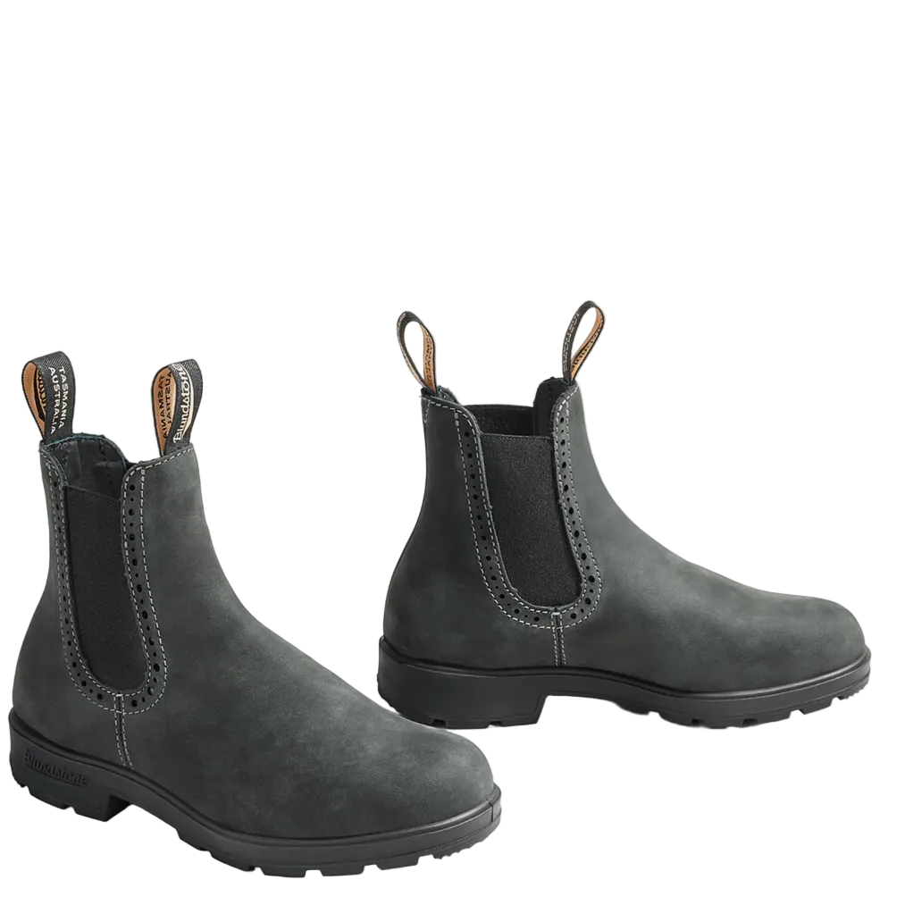 A pair of dark gray suede Chelsea-style ankle boots with black elastic side panels and pull tabs, photographed on a clean off-white studio background.