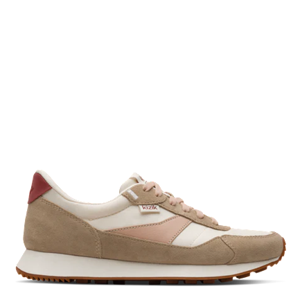 A low-top sneaker shown in profile against a solid white background. The shoe features a beige suede upper with cream and light pink leather panels, a cream midsole, and a small red heel tab.