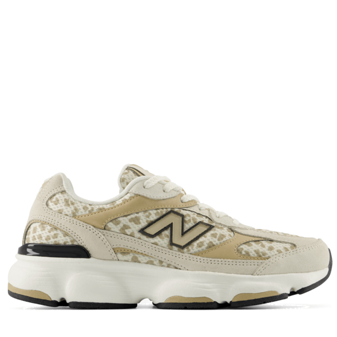 A New Balance sneaker in beige and cream with a textured patterned overlay, shown from the side against a plain white background.