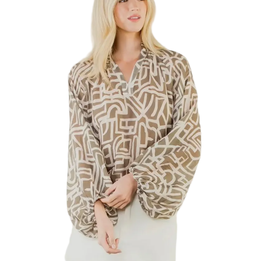 Woman wearing a patterned blouse over a plain dress on a white background
