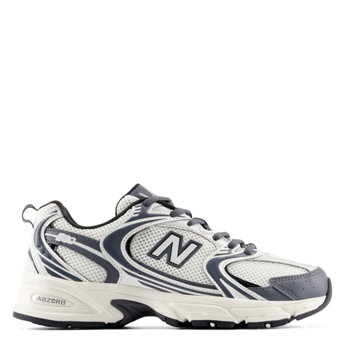 A New Balance athletic sneaker in white, gray, and navy blue, shown from a side profile view against a plain white background.