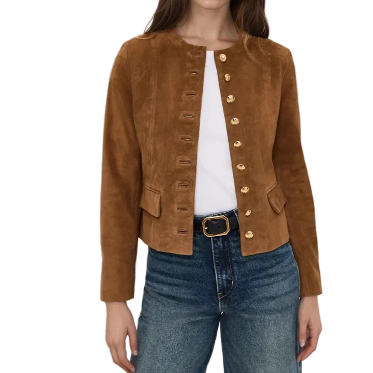 A woman wearing a cropped brown suede jacket with gold-tone decorative buttons down the front, styled over a white top and blue jeans.