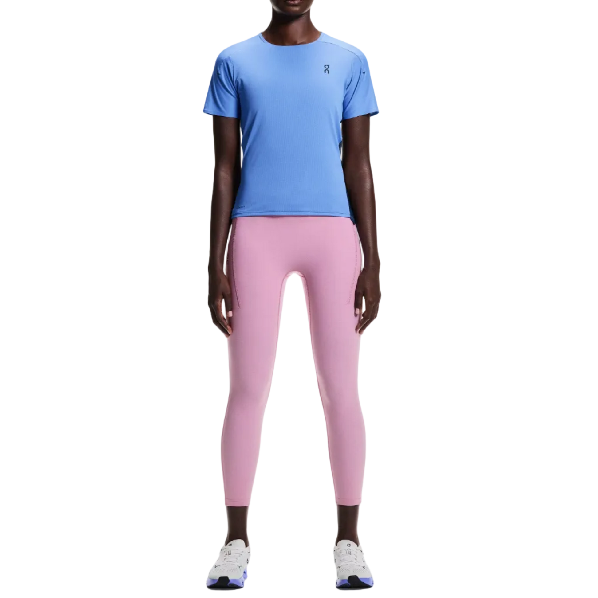 Person wearing a blue athletic shirt and pink leggings on a white background