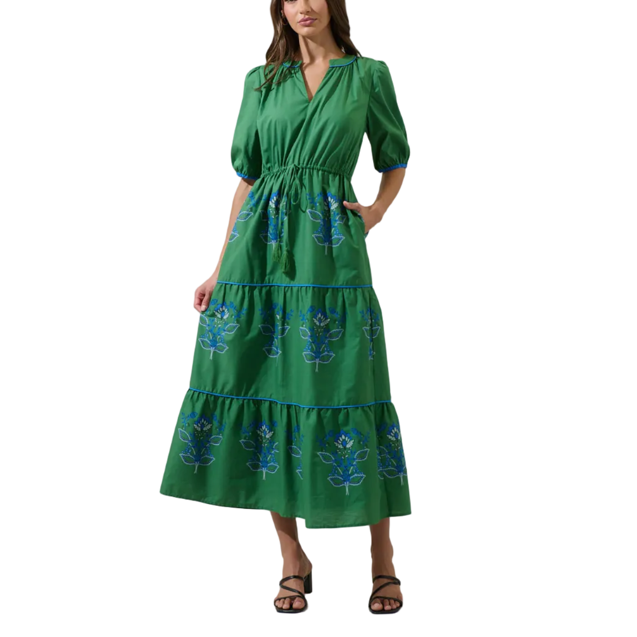 Woman wearing a green dress with floral patterns on a white background